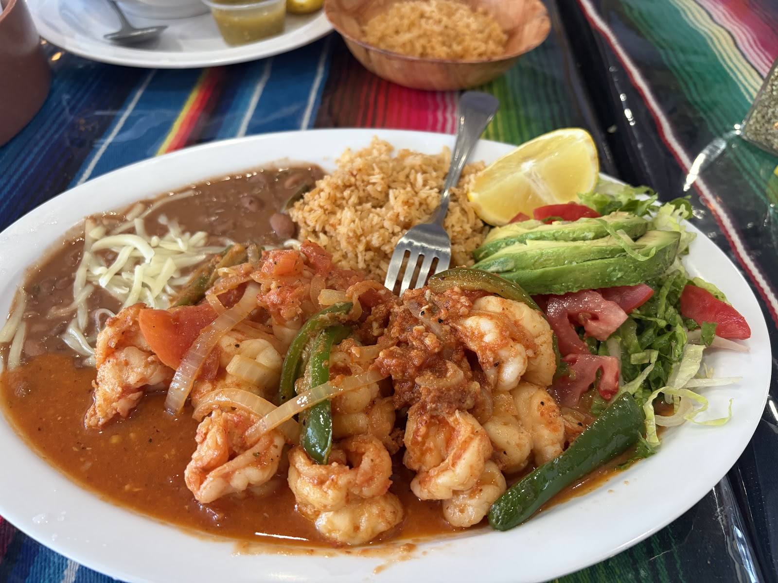 A plate of Camarones a la Diabla with rice, beans, and avocado at Taqueria La Soledad.